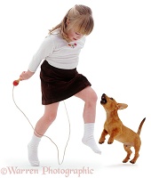 Puppy barking at girl with skipping rope