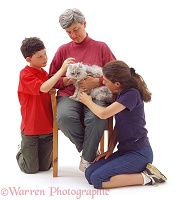 A family loving and stroking an elderly cat
