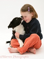 Child being licked by a puppy