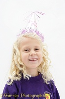 Little girl (5) with birthday party hat on