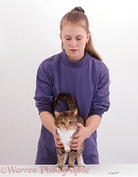 Veterinary nurse feeling tortoiseshell cat for injury