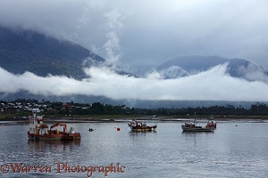 Boats in front of Mountains and low clouds