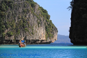 Long-tail boat and limestone cliffs
