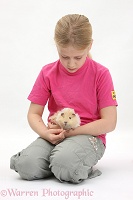 Girl feeding grass to a young Guinea pig