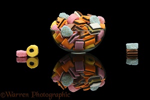 Liquorice all sorts in a glass bowl, black background